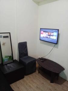 a living room with a chair a table and a tv at Alabang Staycation in Manila