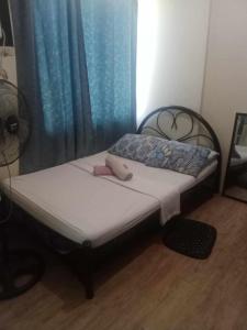 Bett in einem Zimmer mit einem blauen Vorhang in der Unterkunft Alabang Staycation in Manila