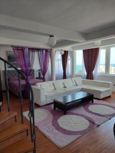 a living room with a white couch and a coffee table at Accommodation Royal Azur in Dobra Voda