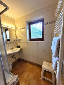 a bathroom with a window and a sink and a toilet at Hotel Sommerer - inklusive JOKER CARD im Sommer in Saalbach Hinterglemm