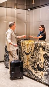 un hombre de pie junto a una mujer con una maleta en Lamartine Hotel en Estambul