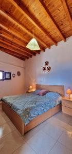 a bedroom with a large bed with a wooden ceiling at Yiannis Village house in Asklipiḯon