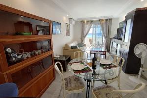 - un salon avec une table et des chaises en verre dans l'établissement Jabeque 1 Dormitorio, à Estepona
