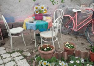 un tavolo con due sedie e un tavolo con fiori di Casa indipendente e con parcheggio a Tricarico, vicino Matera a Tricarico