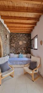 a living room with a blue bed and two chairs at Yiannis Village house in Asklipiḯon