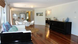 a living room with a white couch and a table at Seaside Holiday Heaven in Hawks Nest