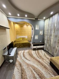 1 dormitorio con cama, escritorio y alfombra grande en Квартира в центре города Тирасполь! Тихий и удобный район!, en Tiraspol