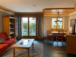 a living room with a red couch and a table at Haus Alpendomizil - Sommer-Bergbahnen kostenlos in Bolsterlang