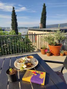 a table with a plate of food on a balcony at Miro guesthouse in Tivat