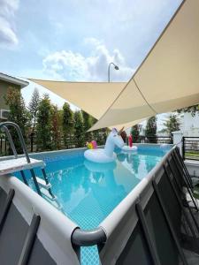 ウル・ティラムにあるHeliconia Design Home With Pool BBQ KTV JB AEON Tebrauのバルコニー(パラソル付)