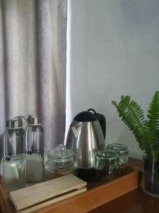 estantería de madera con tetera y jarras de cristal en Kara O Mula Mulanje, en Mulanje