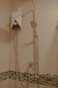 a shower in a bathroom with a shower head at NORN Rimkhlong Bangkok นอนริมคลอง in Bangkok Noi