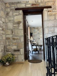 an open door to a room with a stone wall at Griffon Hotel in Yenifoça