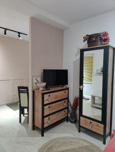a room with a dresser with a mirror and a television at Miro guesthouse in Tivat