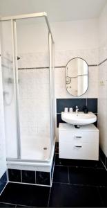 La salle de bains est pourvue d'une douche, d'un lavabo et d'un miroir. dans l'établissement The World, Stilvolles Apartment, Stadtzentral, Parking Free, Late Check In, à Magdebourg