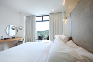 a hotel room with a white bed and a window at The RIYAZ Lavanya in Pantai Cenang