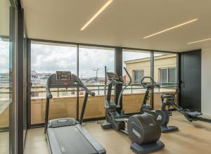 einen Fitnessraum mit Laufbändern und Crosstrainern in einem Gebäude in der Unterkunft Hotel Miraparque in Lissabon