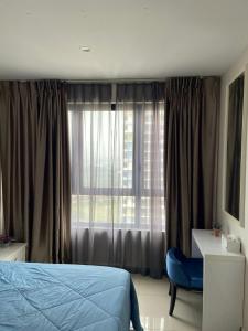 um quarto com uma cama, uma cadeira e uma janela em Orak Villa @ I-City Golden Triangle em Shah Alam