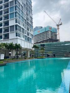 uma grande piscina azul em frente aos edifícios em Orak Villa @ I-City Golden Triangle em Shah Alam