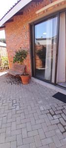 a patio with a bench in front of a brick building at Darize Self Catering Flat in Kimberley