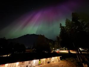 an aurora lights up the sky over a building at Inntowne Motel in Hope