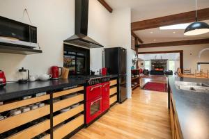 a kitchen with black counter tops and red appliances at Korepo Lodge @ Ruby Bay in Nelson