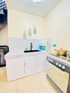 eine weiße Küche mit Spüle und Herd in der Unterkunft 3 Bedroom House near Davao Airport in Davao City