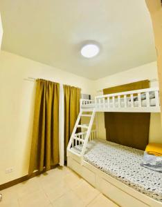 ein Zimmer mit zwei Etagenbetten und einem Fenster in der Unterkunft 3 Bedroom House near Davao Airport in Davao City