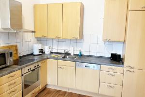Una cocina con gabinetes de madera y un fregadero. en Work & Stay in Celle, en Celle