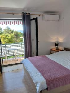 um quarto com uma cama e vista para uma varanda em Apartments Andrea em Drvenik