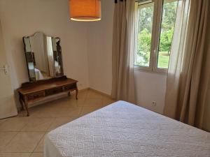 een slaapkamer met een spiegel op een ladekast naast een raam bij Maison jumelée clôturée in Linguizzetta