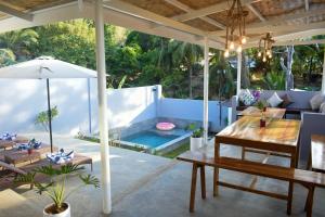 a patio with a table and an umbrella at Orchids Villa Elnido in El Nido