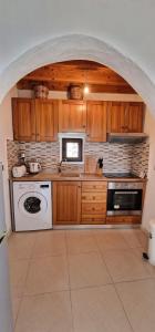 una cocina con armarios de madera y un aparato blanco en Yiannis Village house, en Asklipiḯon