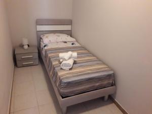 a small bed with towels on it in a room at La casa di Ross in Casteldaccia