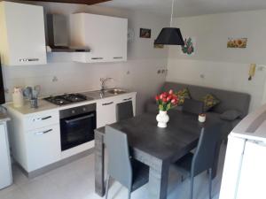 a kitchen with a stove and a table with chairs at La casa di Ross in Casteldaccia