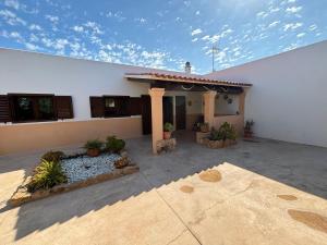 a white building with a patio with plants at Can Moya in Sant Ferran de Ses Roques