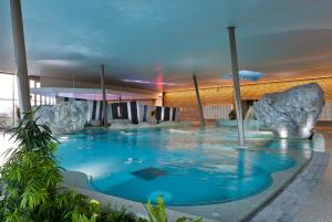 - une grande piscine avec des rochers dans un bâtiment dans l'établissement Gite Riquewihr "C'est Beau la Vie Alsace", à Riquewihr