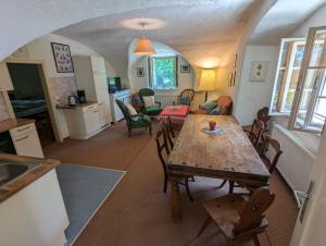 a kitchen and living room with a wooden table and chairs at Ferienwohnung Ottmanach Josefhof in Pischeldorf