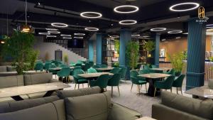 un ristorante con sedie e tavoli verdi e un tavolo di Harris Hotel a Tashkent