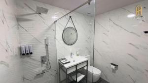 un bagno bianco con lavandino e doccia di Harris Hotel a Tashkent