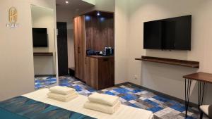una camera d'albergo con TV a schermo piatto e asciugamani di Harris Hotel a Tashkent