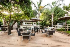 a patio with tables and chairs and umbrellas at Villa Bermeja in Casares