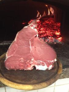 un pedazo de carne está siendo cocinado en un horno en B&B Casa Gori, en Greve in Chianti