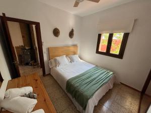a bedroom with a bed and a table and a window at Can Moya in Sant Ferran de Ses Roques