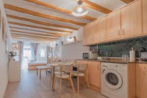 a kitchen with a table and a washing machine at Sweet Sedassos in Tarragona