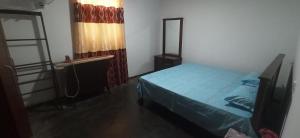 a bedroom with a bed and a mirror and a window at Tamarind Ceylon Homestay in Ambalantota
