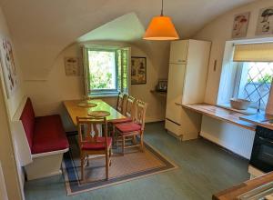 een keuken en eetkamer met een tafel en stoelen bij Ferienwohnung Ottmanach Schlosshof in Pischeldorf
