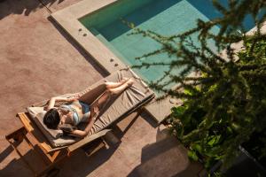 une femme qui pose sur un banc à côté d'une piscine dans l'établissement Medite Spa Resort and Villas, à Sandanski