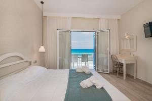 a hotel room with a bed and a view of the ocean at Filoxenia Beach in Tsilivi
