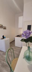 a room with a vase with purple flowers on a table at Casa Vacanze L'Ortensia in Bagheria